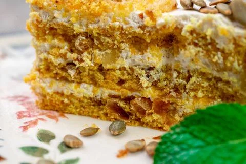 Close-up of appetizing slice of homemade pumpkin cake with sour cream and Stock Photos