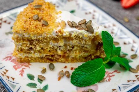 Close-up of appetizing slice of homemade pumpkin cake with sour cream and Stock Photos