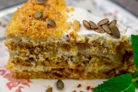 Close-up of appetizing slice of homemade pumpkin cake with sour cream and Stock Photos