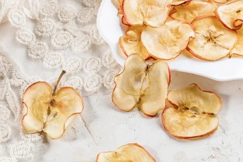 Close-up apple chips on white table and figured plate. 写真素材