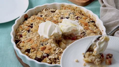 Close up apple pear crumble with ice cream, streusel. Woman putting pie on plate Stock Footage 151429633