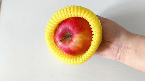 Close-up of an apple in a yellow foam net in your hand 库存影片 332410012