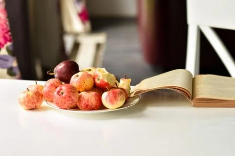 Close up of apples with book on white table Stock Photos