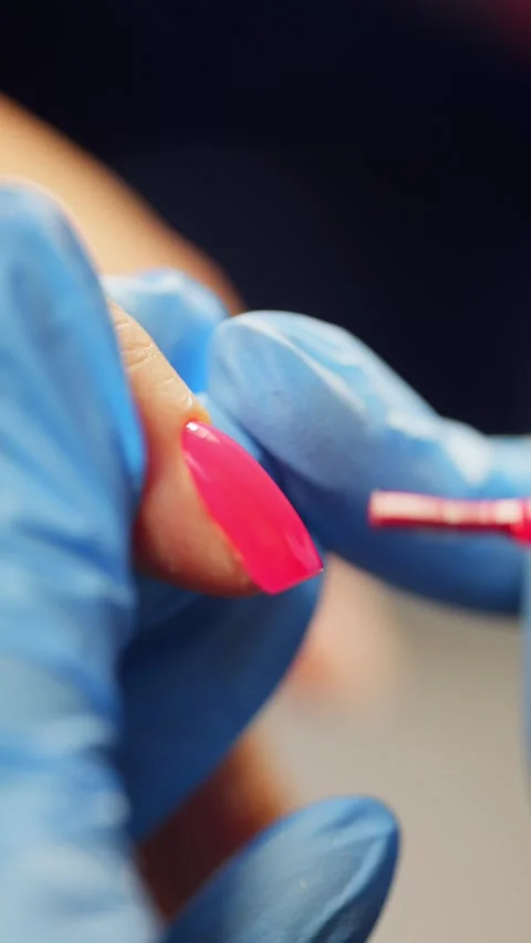 Close-up of applying bright gel polish to a nail with a brush. Stock Footage 322130653