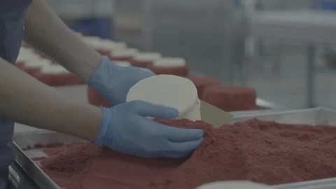Close-up of applying red cake crumbles to a frosted round cake Stock-Footage 327358471