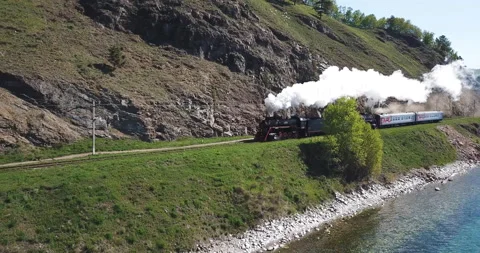 Close approach passengers train Trans Siberian railway brick bridge. Lake Baikal Stock Footage 123408412