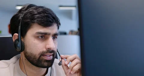 Close up of Arab handsome man in headset working at computer screen, talking Stock Footage 179987891