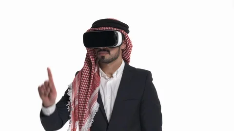 Close-up of Arab man in VR goggles pointing at virtual objects, exploring Stock Footage 125830060