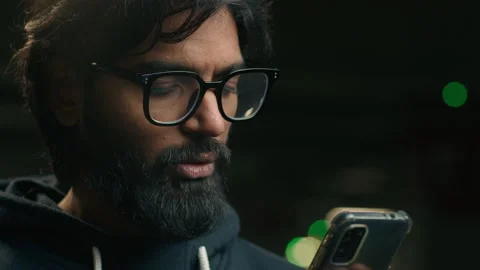 Close up Arabian user guy looking at smartphone in dark city Indian man chatting Video stock 252747721
