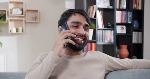 Close up of Arabian young man talking on smartphone. At home. Handsome male Stock Footage 179944198