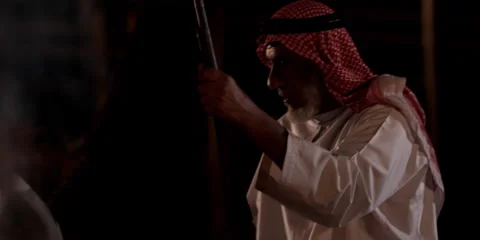 Close-up of Arabic men sitting and talking around a camp fire at night. Stock Footage 46870565