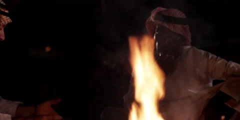 Close-up of Arabic men talking, while sitting around a camp fire. Stock Footage 46870541