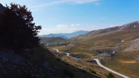 Close Arc Movement Around Hillside Tree Revealing Wide Mountain Range Panora Stock Footage 321858727