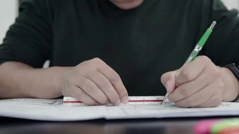 Close-up of architect Man’s hands drawing lines on the Large Format Paper at Stock Footage 336565155