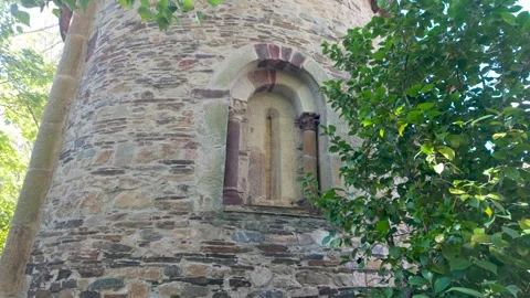 Close architectural view of a narrow arched window set into the weathered stone Stock Footage 344341841