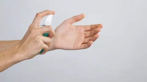 Close-up of arm with antibacterial spray spreading on arms with slow motion Stock Footage 127113689