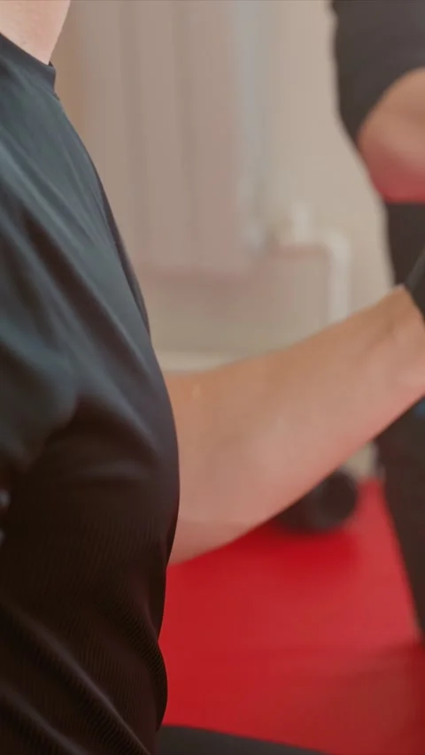 Close up arm massage with gloved hands on extended forearm in indoor gym setting Stock Footage 345548749