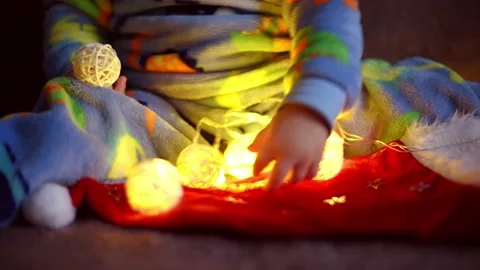 Close-up arms of kid boy playing with christmas  garland .Magic vibe of new year Stock Footage 220518919