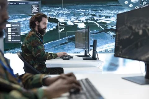 Close up of army analyst working on computer in high tech command center Stock Photos