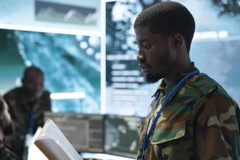 Close up of army officer reading documents in command center Stock Photos