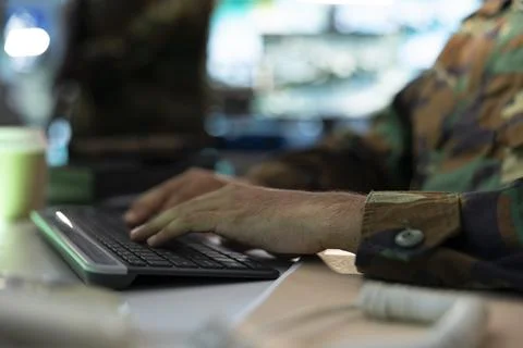 Close up of army operator typing on PC keyboard, providing combat support Stock Photos