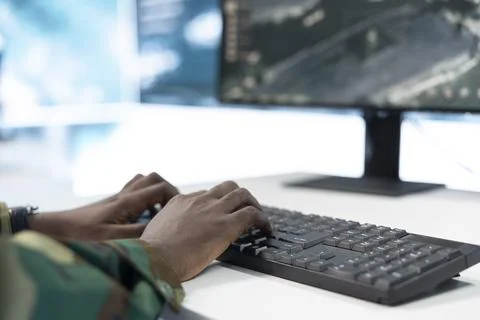 Close up of army soldier typing at command center workstation desk Stock Photos