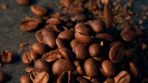 Close-up aroma beans roasted coffee fast falling on textured dark table. Stock Footage 273075362