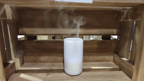 Close up of aroma oil diffuser on the table at home, steam from the air hum.. Video stock 254309641