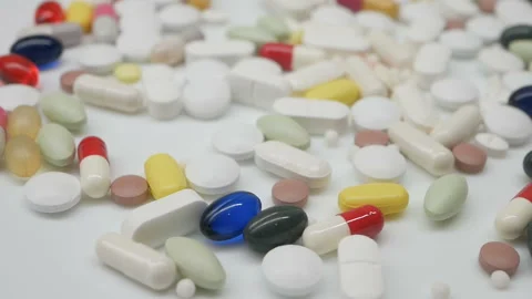 Close up, around rotating with red, white, colored pills Video stock 86213515