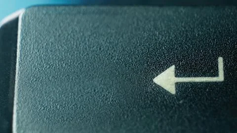 Close-Up of an Arrow Key on a Computer Keyboard Against a Soft Blue Background Stock Photos