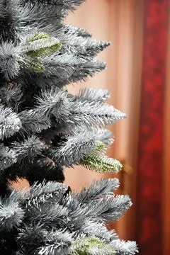 A close-up of an artificial Christmas tree with flocked finish, giving it a.. Stock Photos
