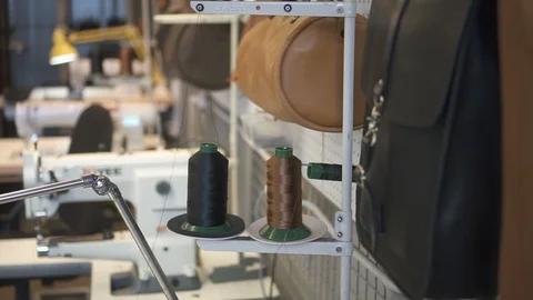 Close up of artificial leather bag hangling in the workshop with sewing machines Stock Footage 120409108