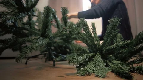 Close up. Artificial needles of the Xmas tree on the wood floor. Girl in a dark  Video stock 163452870