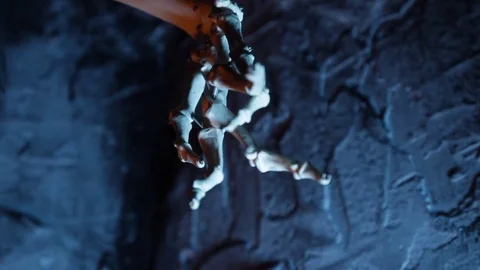 Close up of artificial skeleton arm in the dark blue cave Stock Footage 70453353