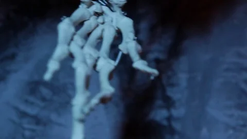 Close up of artificial skeleton arm in the dark blue cave Stock Footage 70453393