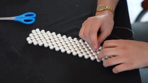 Close-up of Artisan Adjusting Tension on Large Pearl Mesh for Luxury Accessory Vídeos de archivo 333563196