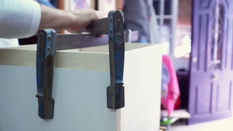 Close up on artisan assembling wooden planks together with large metal Stock Footage 220758565