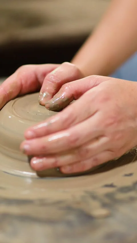 Close-up of Artisan Hands Shaping Wet Clay on a Pottery Wheel Stock Footage 341536080