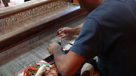 Close up of artisan hands weaving traditional colorful textile on wooden loom Stock Footage 342705801