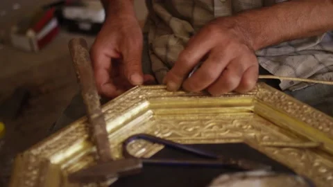 Close up of artisan hands working on a gold metal frame in smith shop in Morocco Video stock 168702482