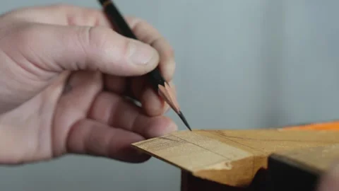 Close-up. an artisan marks out a piece of wood with a simple pencil. fhd Stock Footage 156669305
