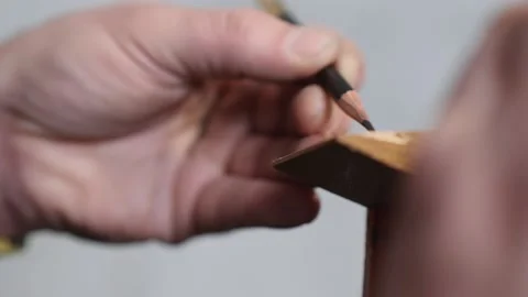 Close-up. an artisan marks out a piece of wood with a simple pencil Stock Footage 156669359