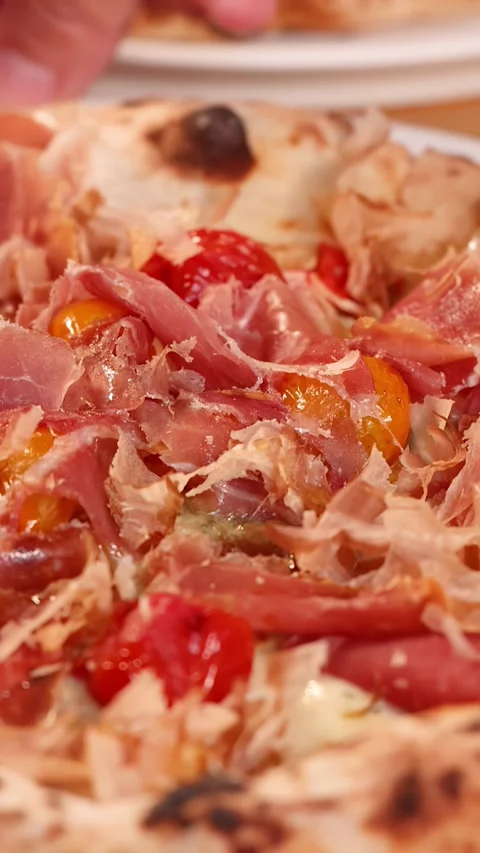 Close Up of Artisan Pizza with Prosciutto and Cherry Tomatoes Stockbeeldmateriaal 337770820