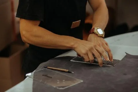 Close up of an artisan working with leather in his laboratory using tools Stock-Fotos