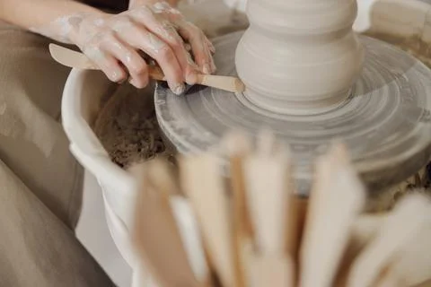 Close up of artisan's hands shaping clay bowl in pottery studio. Pottery art and Stock Photos