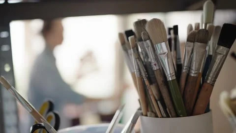 Close up of artist paintbrushes with painter in the background 库存影片 344316705