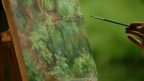 Close-up of an artist's hand with a brush doing the blurring touches over her Stock Footage 116655116