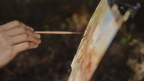 Close-up, the artist's hand with a brush paints a landscape of an autumn forest Video stock 337121254