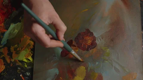 Close-up, artist's hand drawing a picture with flowers with oil paints in art Stock Footage 264361675