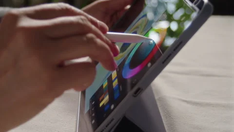 Close-up, the artist's hand holds a tablet and chooses a palette to paint a Video stock 337121360